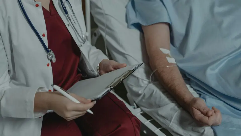 Homem doente ao lado de sua médica.
