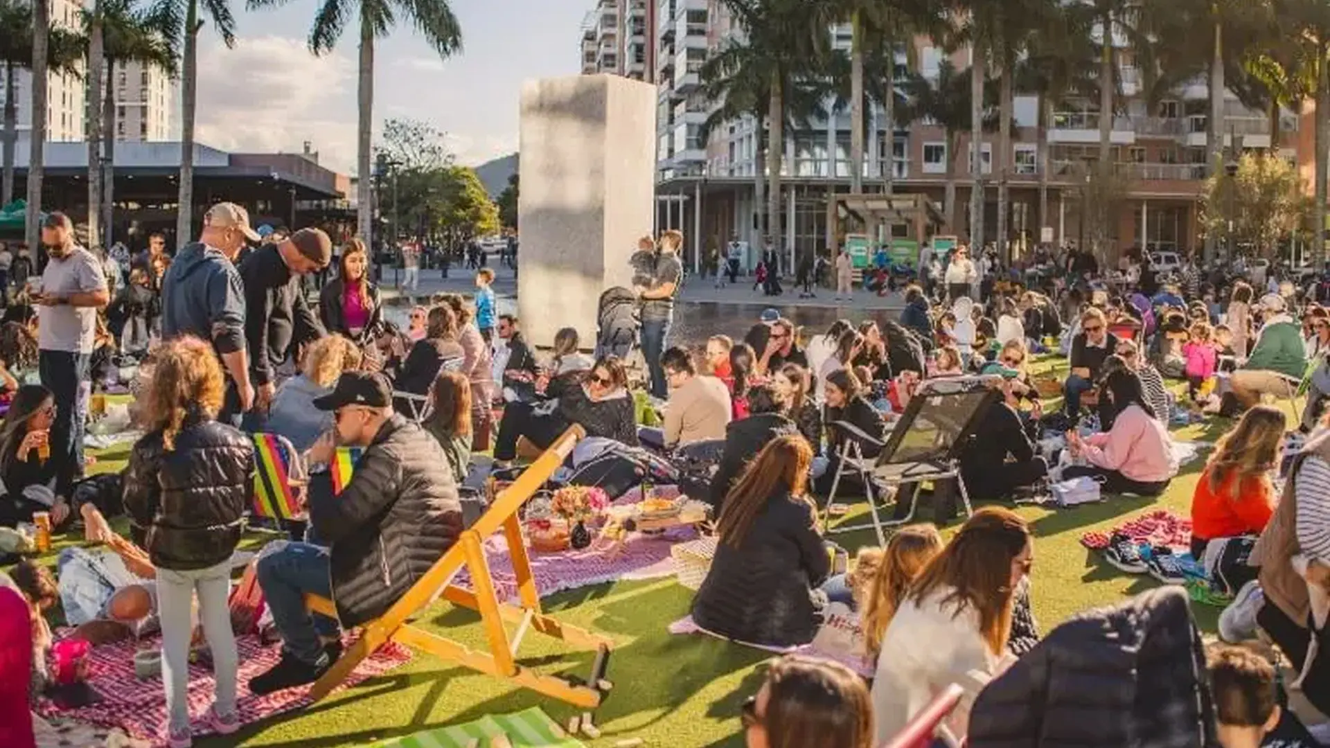 Famílias aproveitam a tarde de sol na Praça do Passeio Pedra Branca durante evento cultural em outubro.