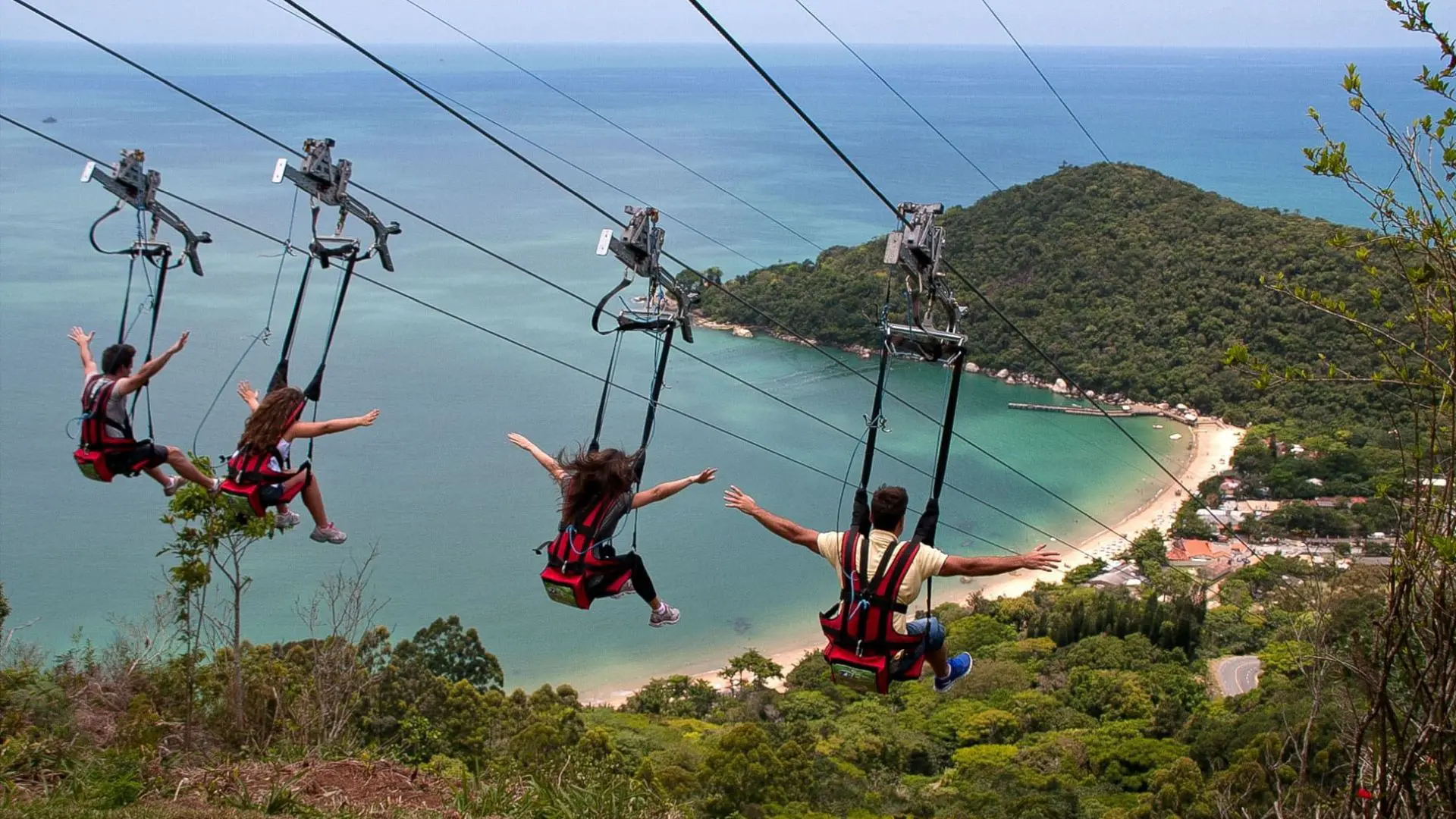 Turistas descem pela tirolesa ZipRider, no Parque Unipraias, em Balneário Camboriú (SC), que liga o Morro da Aguada à Praia de Laranjeiras.