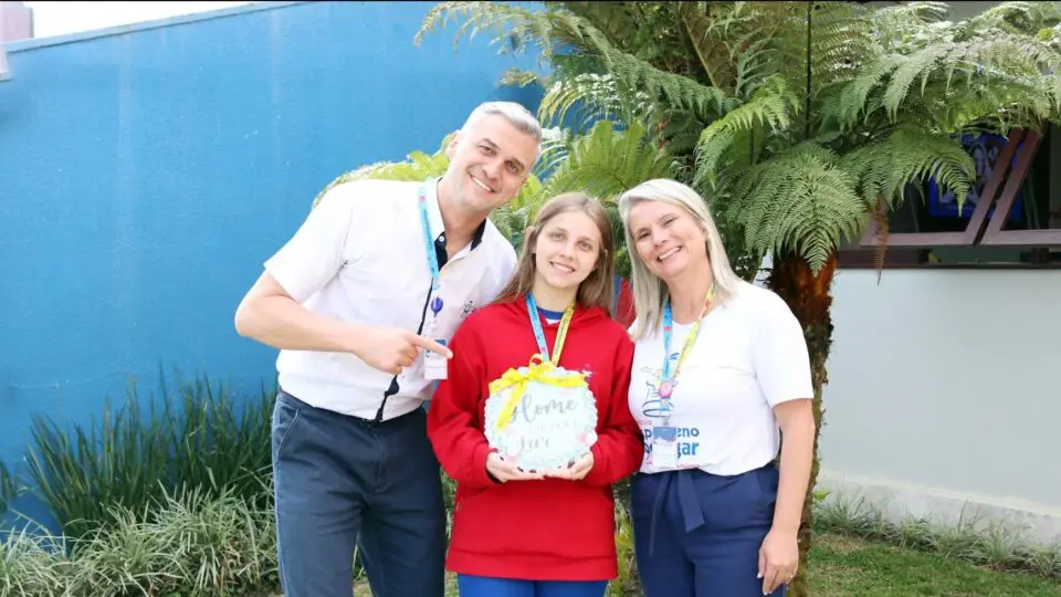 A Escola O Pequeno Polegar celebrando as conquistas de sua equipe. Na foto, a colaboradora Kamille comemora a realização do sonho da casa nova, um reflexo do ambiente de valorização e apoio que faz da instituição um Great Place To Work.
