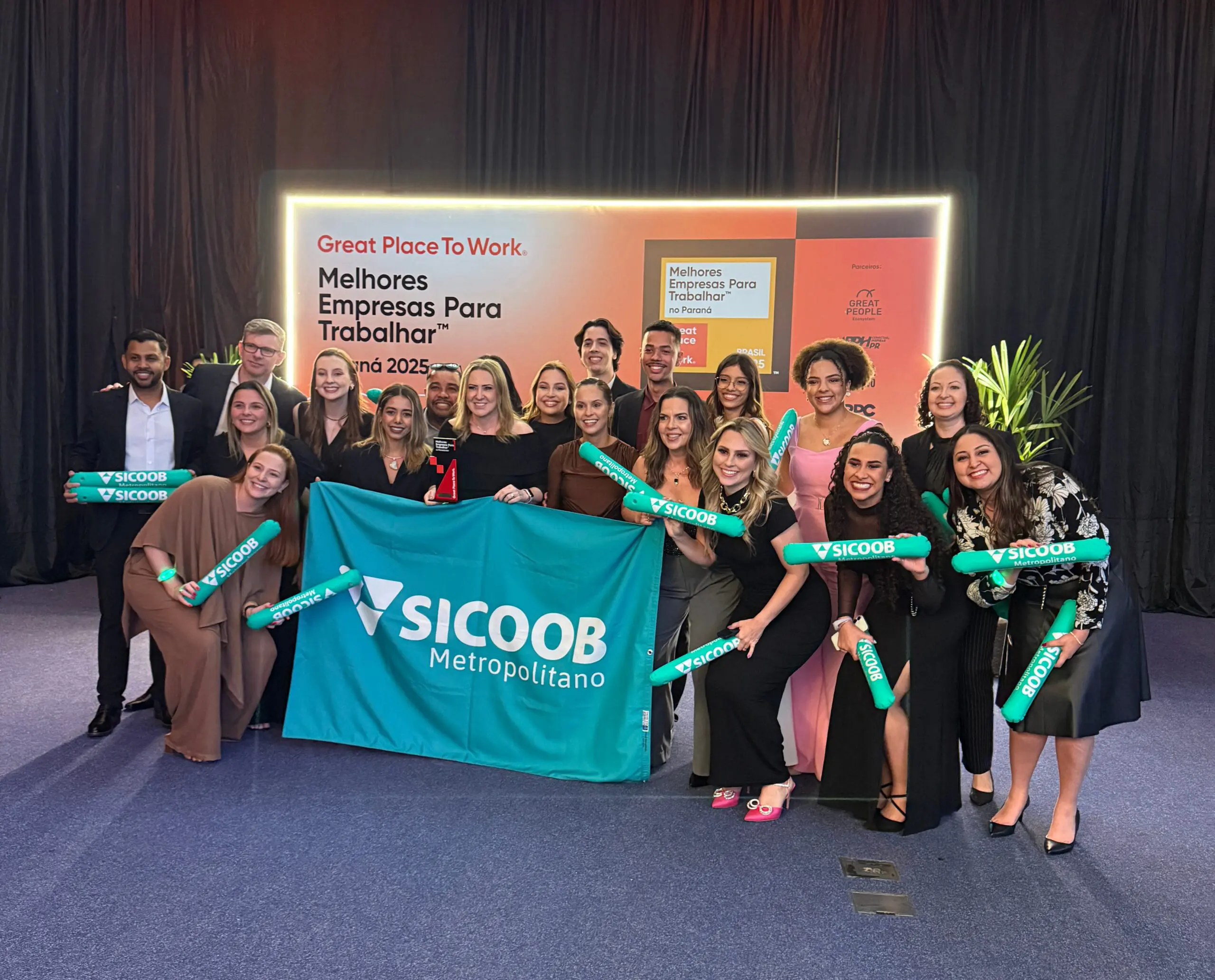 A dedicação diária e o compromisso de cada colaborador foram os pilares para a conquista do 1º lugar no GPTW Paraná 2025. Na foto, a equipe do Sicoob Metropolitano celebra o prêmio que reflete a cultura de excelência e o ambiente colaborativo construído por eles, no dia a dia.