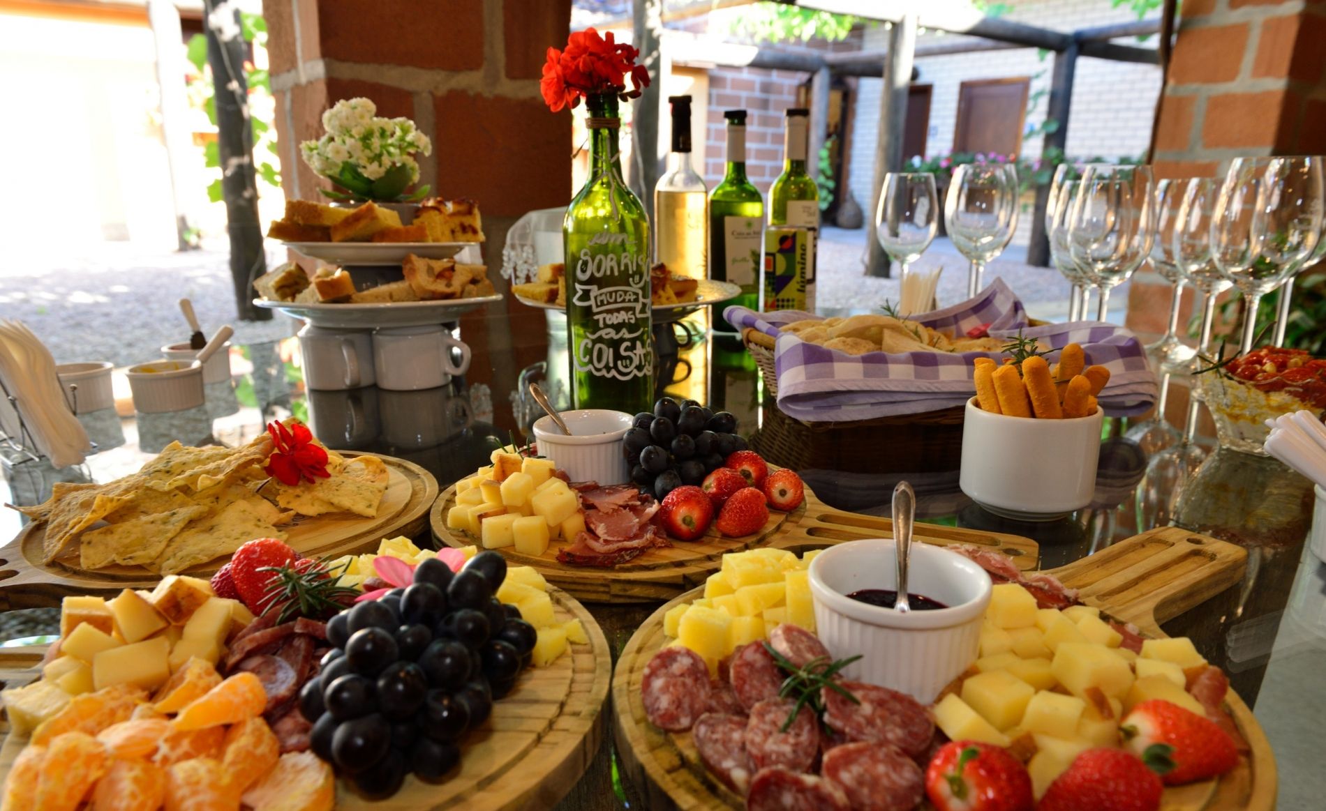 Mesa de degustação em vinícola catarinense: harmonização de vinhos, queijos e frutas em meio ao clima e às paisagens da primavera.