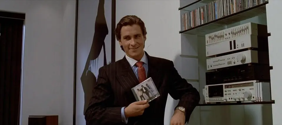 O personagem Patrick Bateman segura um CD da banda Huey Lewis and the News