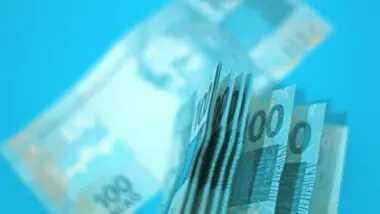 Notas de cem reais em um fundo azul.