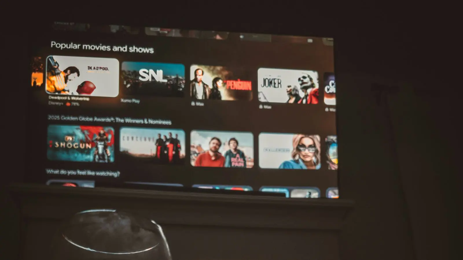 Pessoa assistindo na TV filmes e séries novas de ação