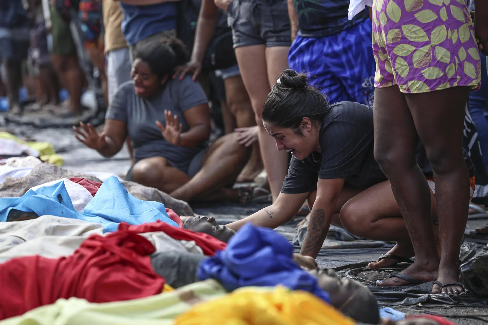 Moradores levam corpos de suspeitos mortos para recinhecimento de famílias em praça no Complexo da Penha
