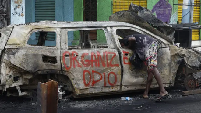 Território controlado: carro incinerado durante Operação Contenção. A denúncia do Ministério Público à Justiça fala em tortura de moradores e avanço rápido pela zona norte do Rio.