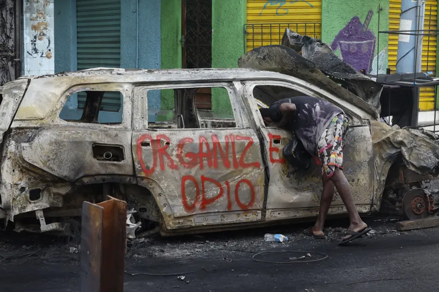 Território controlado: carro incinerado durante Operação Contenção. A denúncia do Ministério Público à Justiça fala em tortura de moradores e avanço rápido pela zona norte do Rio.