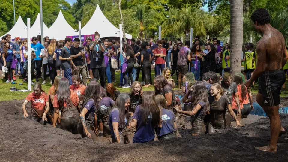 Os calouros da PUCPR mergulharam no banho de lama organizado pela universidade para comemorar a aprovação.