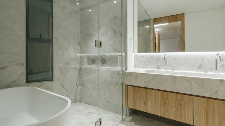 Mármore e a luz linear criam um ambiente de bem-estar cotidiano, inspirado na experiência de spa.   