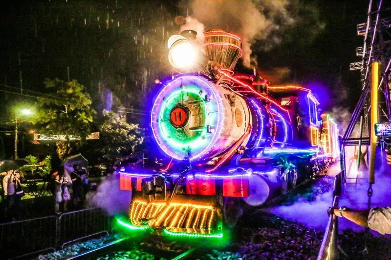 A Maria Fumaça iluminada cruza Curitiba como um filme em movimento, levando o espírito do Natal do Paraná pelos trilhos da cidade.