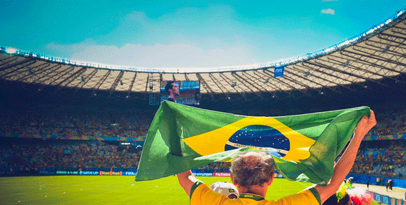  Homem segurando bandeira do Brasil em um estádio torcendo por um artilheiro na Copa do Mundo
