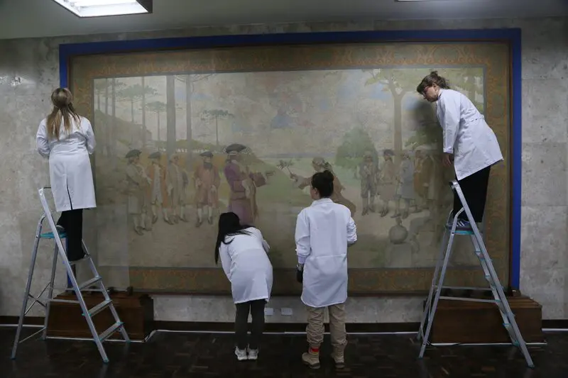 O processo técnico permitirá que a pintura centenária volte ao Salão Nobre com melhores condições de conservação.