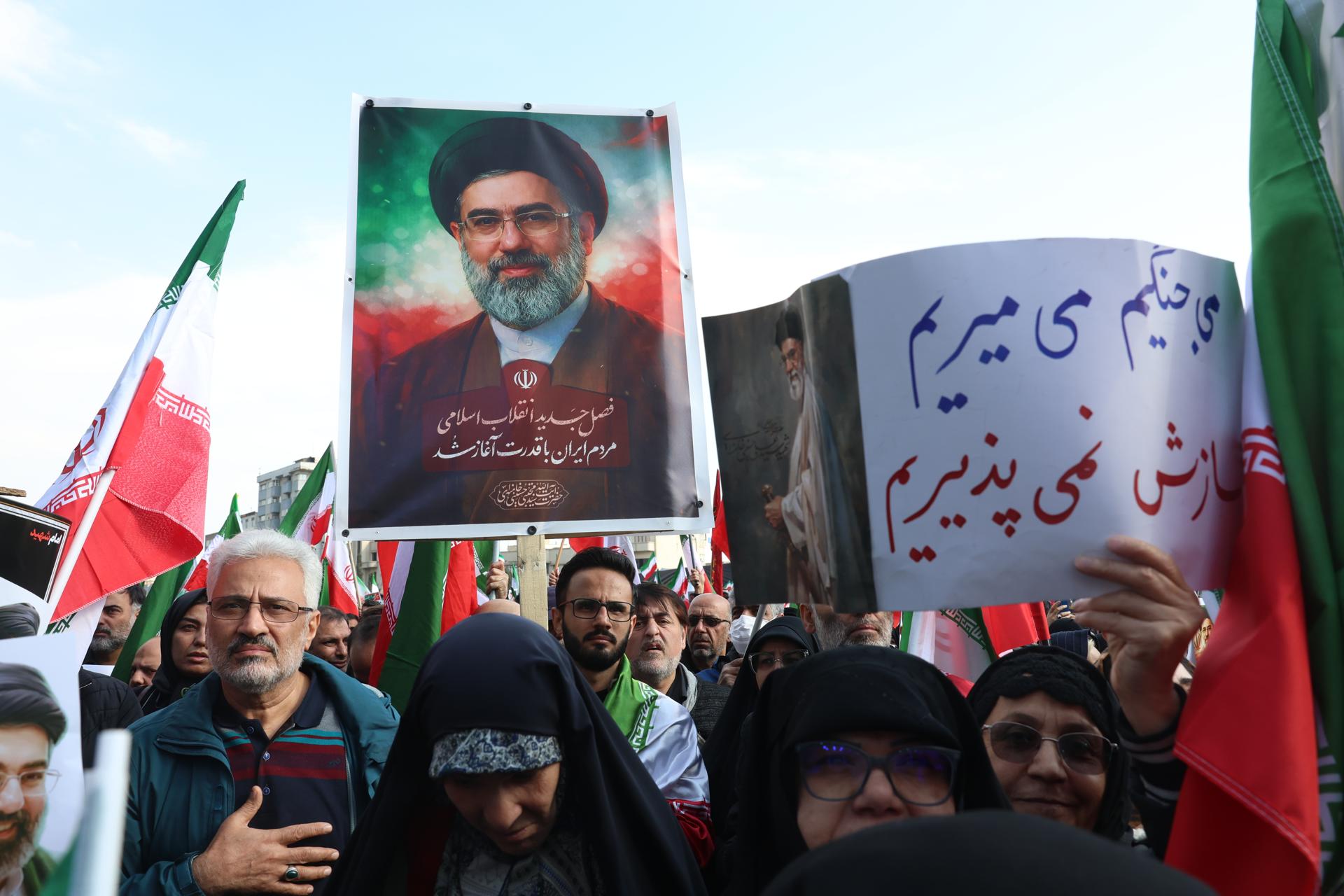 Iraniano segura foto do novo líder supremo do Irã, o aiatolá Mojtaba Khamenei, durante manifestação em Teerã.
