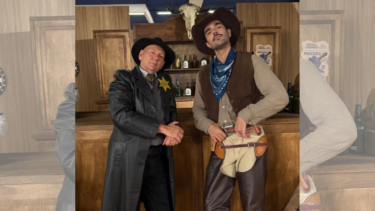 empresário dono da Havan, Luciano Hang, vestido com sobretudo preto, chapéu preto ao lado do cantor Luan Pereira vestido de cowboy em uma campanha do velho oeste