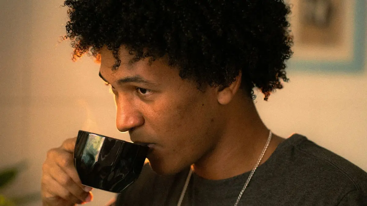 Homem bebendo uma xícara de café.