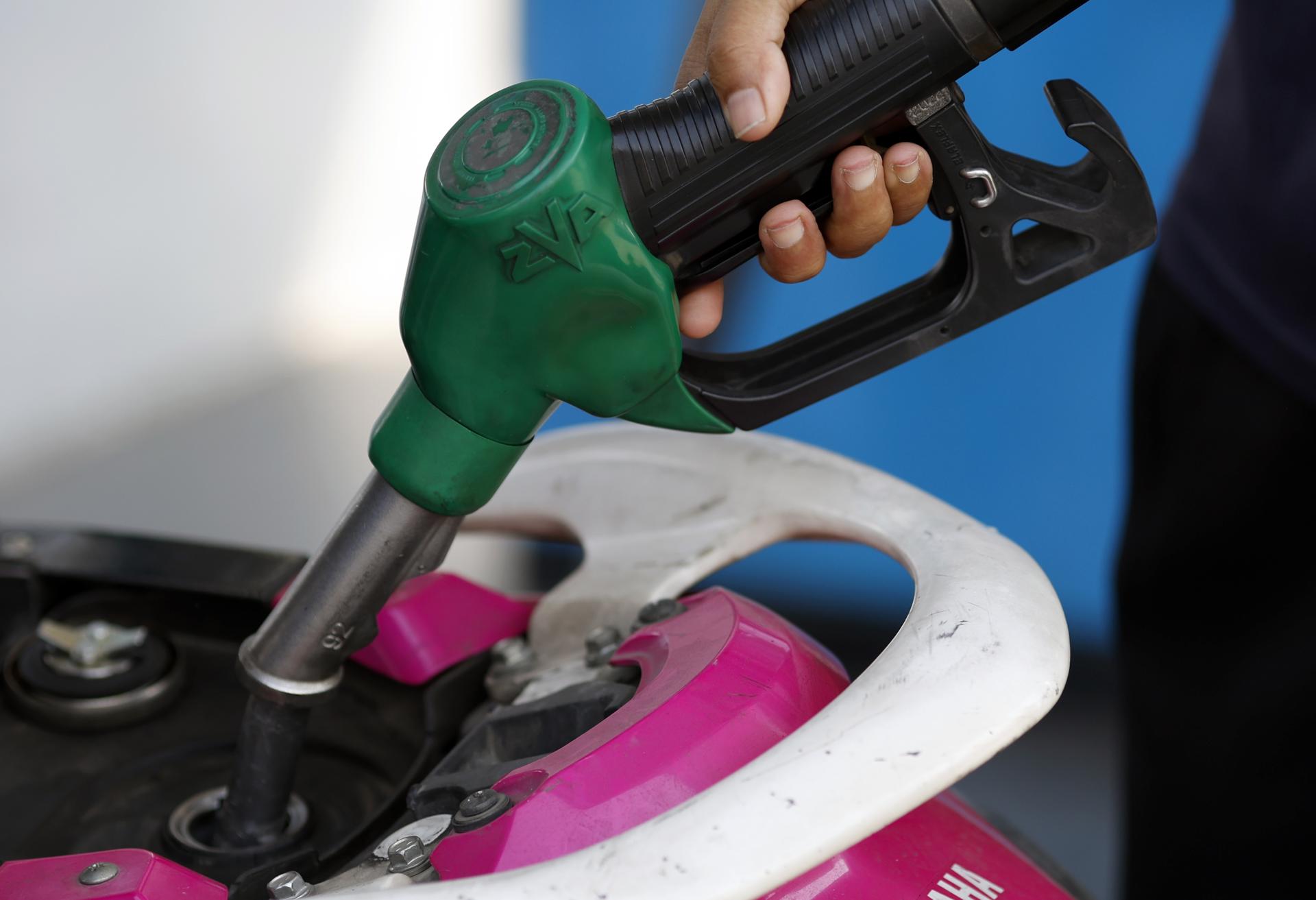 Homem abastecendo uma motocicleta em um posto na Tailândia. País é um dos que estão tendo que tomar iniciativas para conter a crise do petróleo.