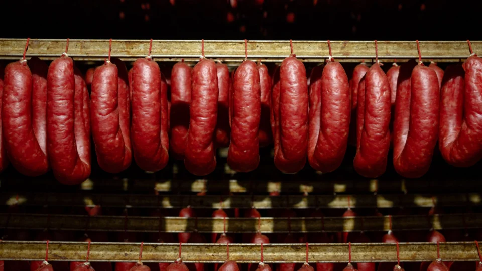 Linguiça Blumenau da Olho Embutidos, produzida em Pomerode (SC), mantém tradição alemã com receita artesanal e defumação lenta.