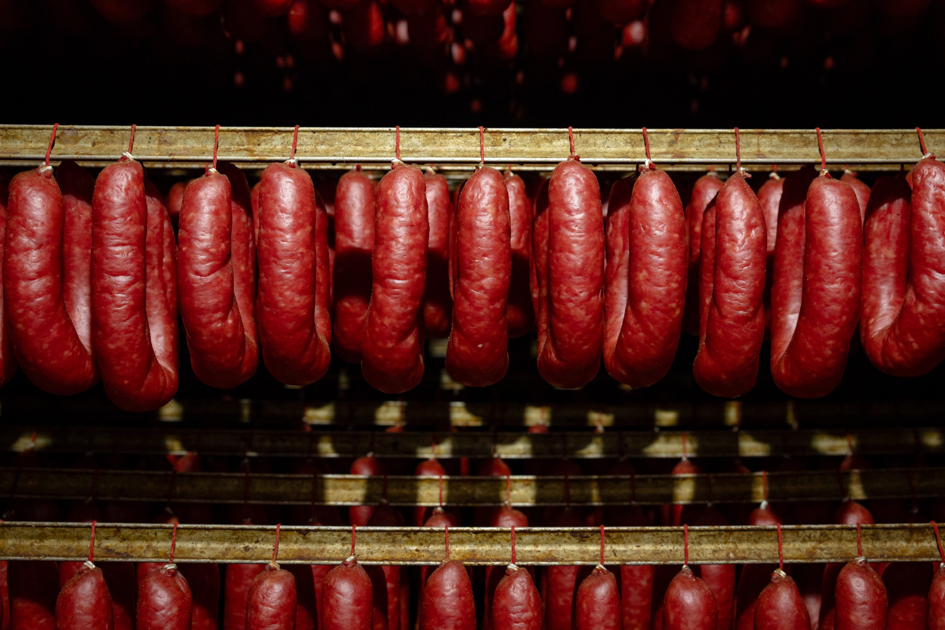 Linguiça Blumenau da Olho Embutidos, produzida em Pomerode (SC), mantém tradição alemã com receita artesanal e defumação lenta.
