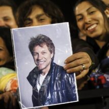 Fã segura cartaz com a foto do cantor John Bon Jovi durante show no Chile, em 2013: adolescência é fase decisiva para a formação das preferências musicais. Imagem referente a matéria