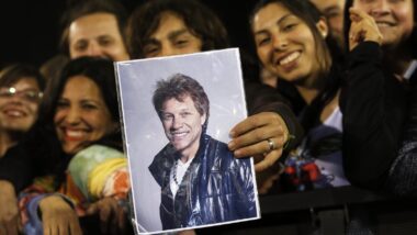 Fã segura cartaz com a foto do cantor John Bon Jovi durante show no Chile, em 2013: adolescência é fase decisiva para a formação das preferências musicais. Imagem referente a matéria