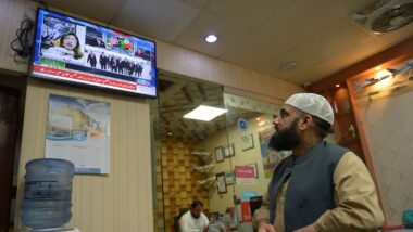 Paquistaneses acompanham noticiário sobre negociações de paz entre EUA e Irã em escritório de Islamabad. Imagem referente a matéria