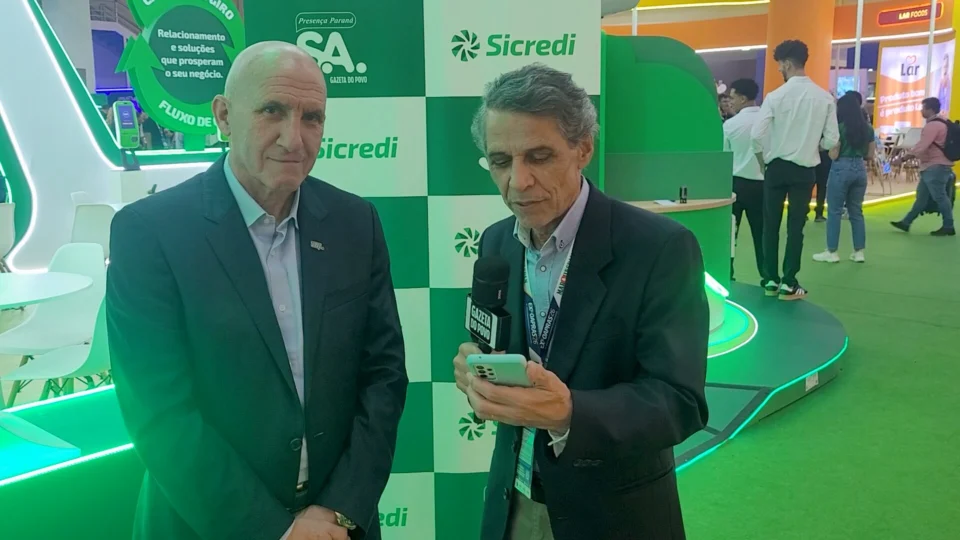 O jornalista Celio Martins entrevista Luiz Roberto Baggio, presidente do Conselho da Ocepar e do Sicredi Integração PR e SC, durante a Expoapras 2026, sobre cooperativismo, supermercados e desenvolvimento econômico.