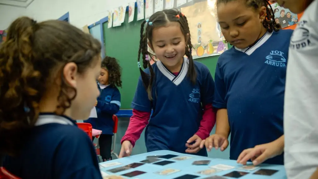 Estudantes participam de atividade lúdica em sala de aula, evidenciando metodologias que estimulam o aprendizado e contribuem para os avanços na alfabetização na rede pública paulista.