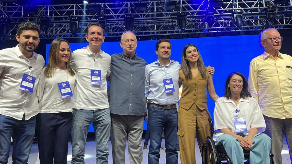 Grupo de pessoas posa para foto em palco durante evento do PSDB em São Paulo.