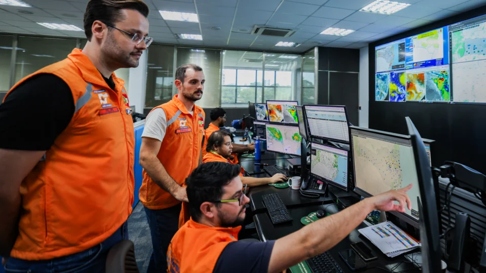 meteorologistas da Defesa Civil em frente a um computador verficando os riscos de ciclone bomba em cidades de Santa Catarina
