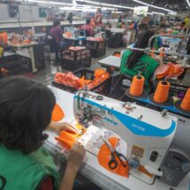 Linha de produção de uma indústria têxtil nacional operando máquinas de costura e tecelagem