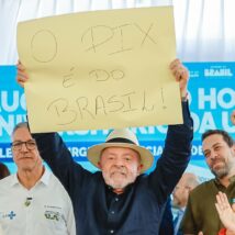 Pix ameaçado? Especialistas veem baixo risco de restrições ao sistema e EUA desmentem sanções a usuários Presidente Lula eleva cartaz em papel craft escrito "O pix é do Brasil" em evento
