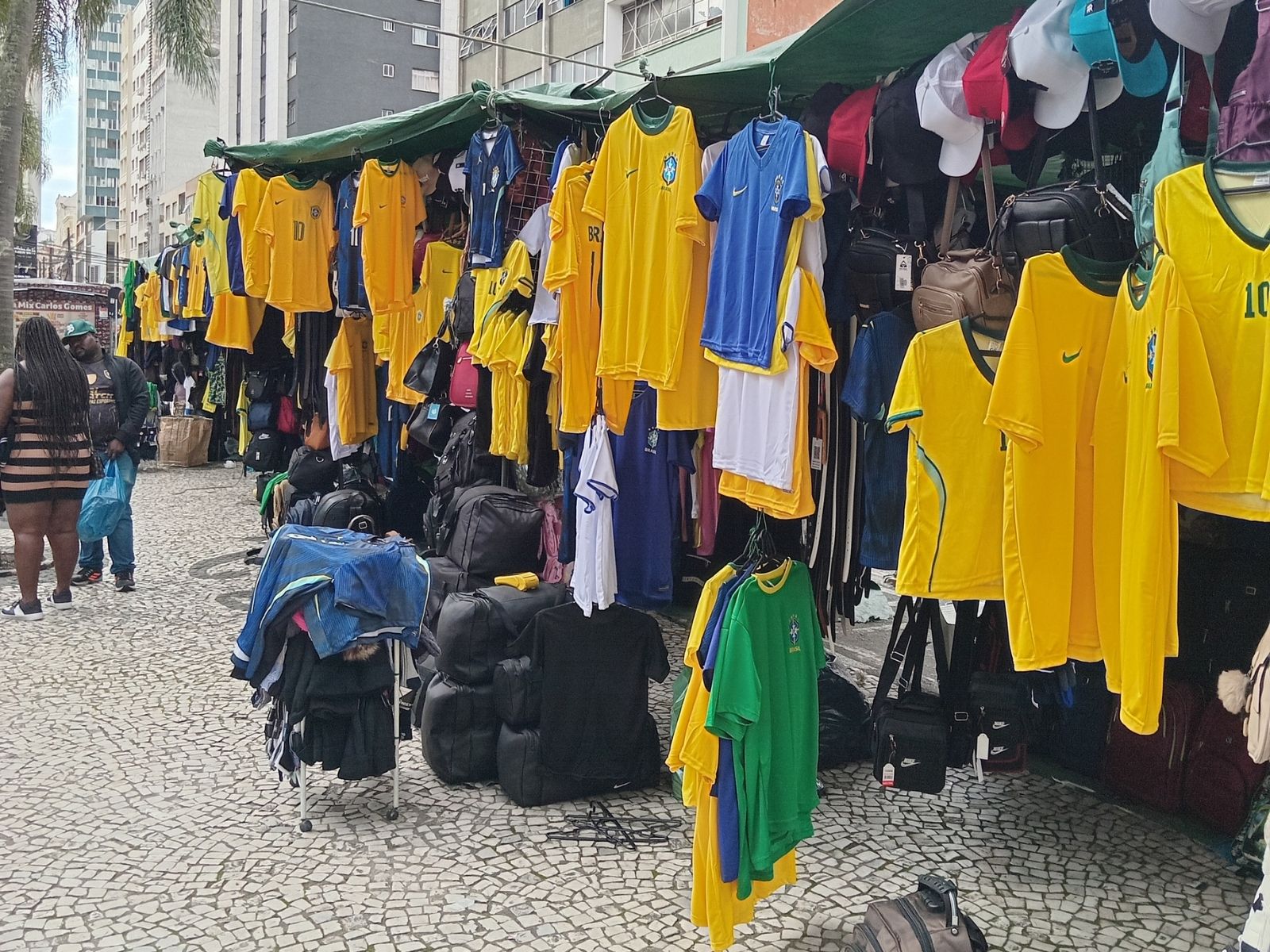Camelôs vendendo camisas do Brasil. Ufa.