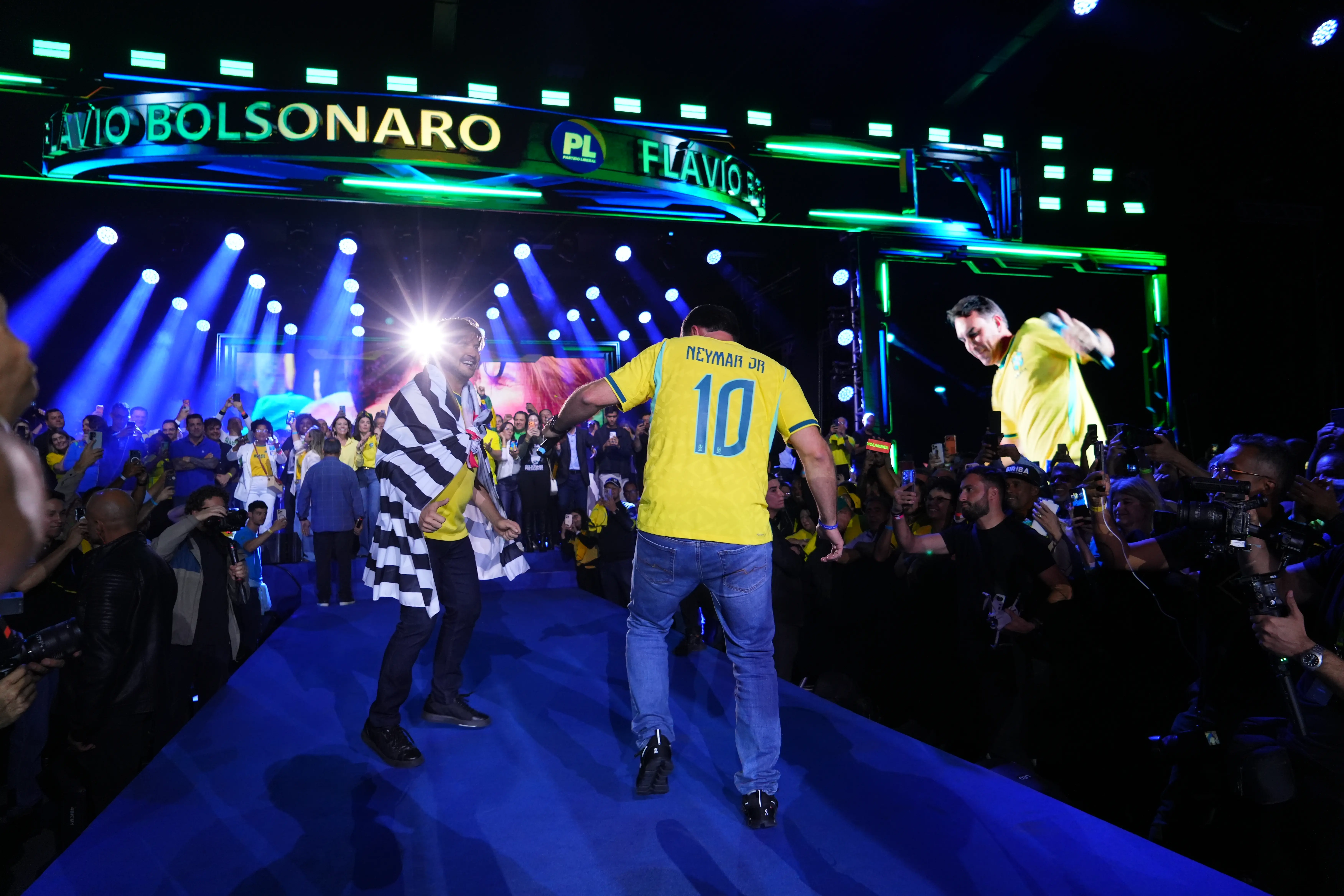 Flávio Bolsonaro veste camisa da seleção com nome e número de Neymar Jr. durante evento de pré-campanha em São Paulo