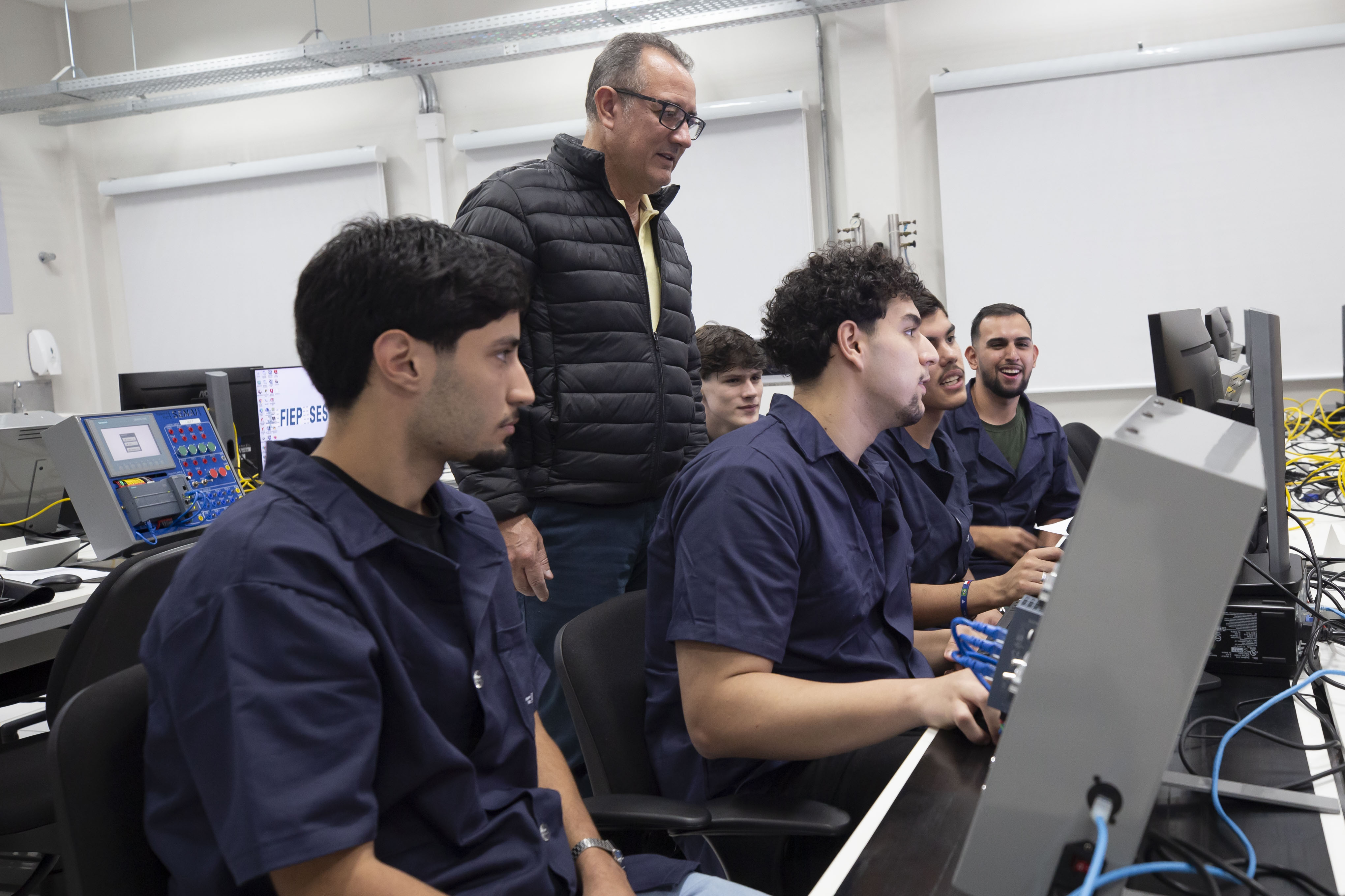 Alunos participam de aula prática em laboratório do Senai Paraná, com acompanhamento de instrutor, em uma formação alinhada às demandas da indústria e às novas tecnologias.