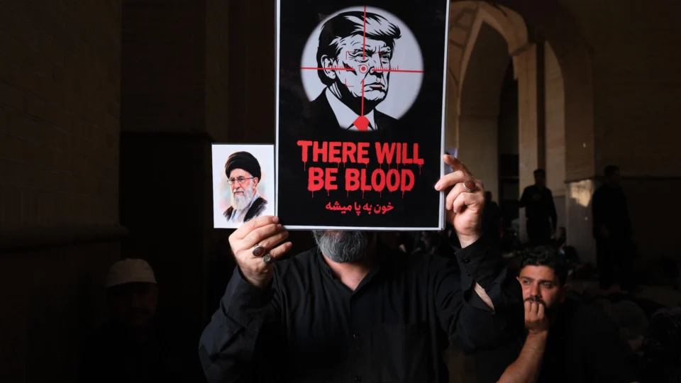Manifestante segura cartaz contra Trump em funeral de Ali Khamenei, no Irã.