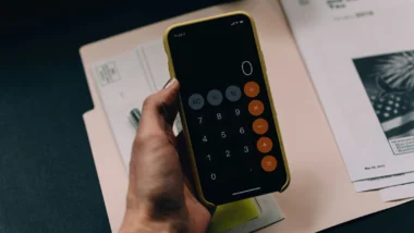 Pessoa com calculadora na mão calculando as taxas da Reforma Tributária.