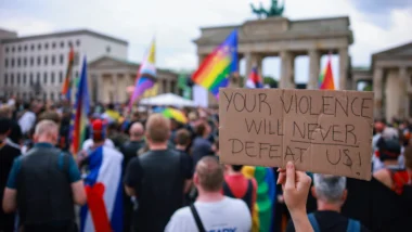 Pessoas lamentam em frente ao Portão de Brandemburgo, próximo ao local onde um veículo foi lançado contra uma multidão ao lado do percurso do desfile da Parada LGBTQ+ em Berlim, na Alemanha, neste 26 de julho de 2026.