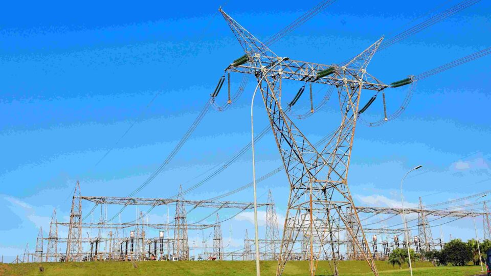 Linhas de transmissão de energia elétrica da usina hidrelétrica Itaipu Binacional sob céu claro.