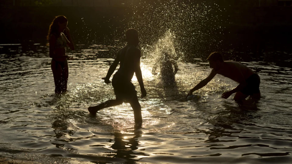 Crianças se divertem em um rio: brincadeira infantil de cócegas e sua sensibilidade são alvos de estudos.