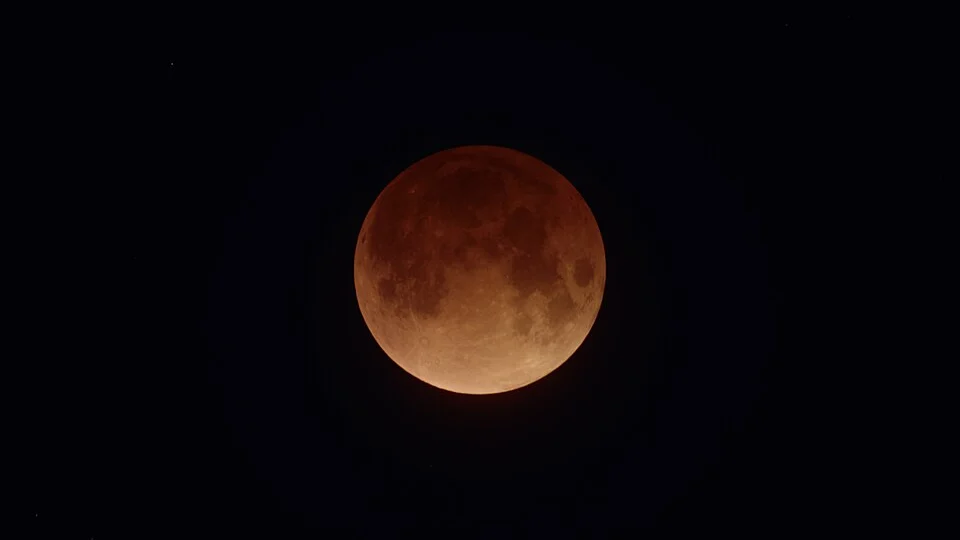 Durante o fenômeno, a luz solar filtrada pela atmosfera terrestre pode fazer com que a Lua adquira tons avermelhados ou acobreados.