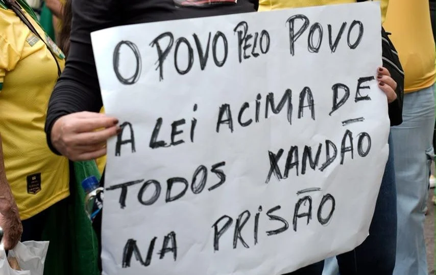 Manifestante com cartaz afirmando que a lei deve estar acima de todos.