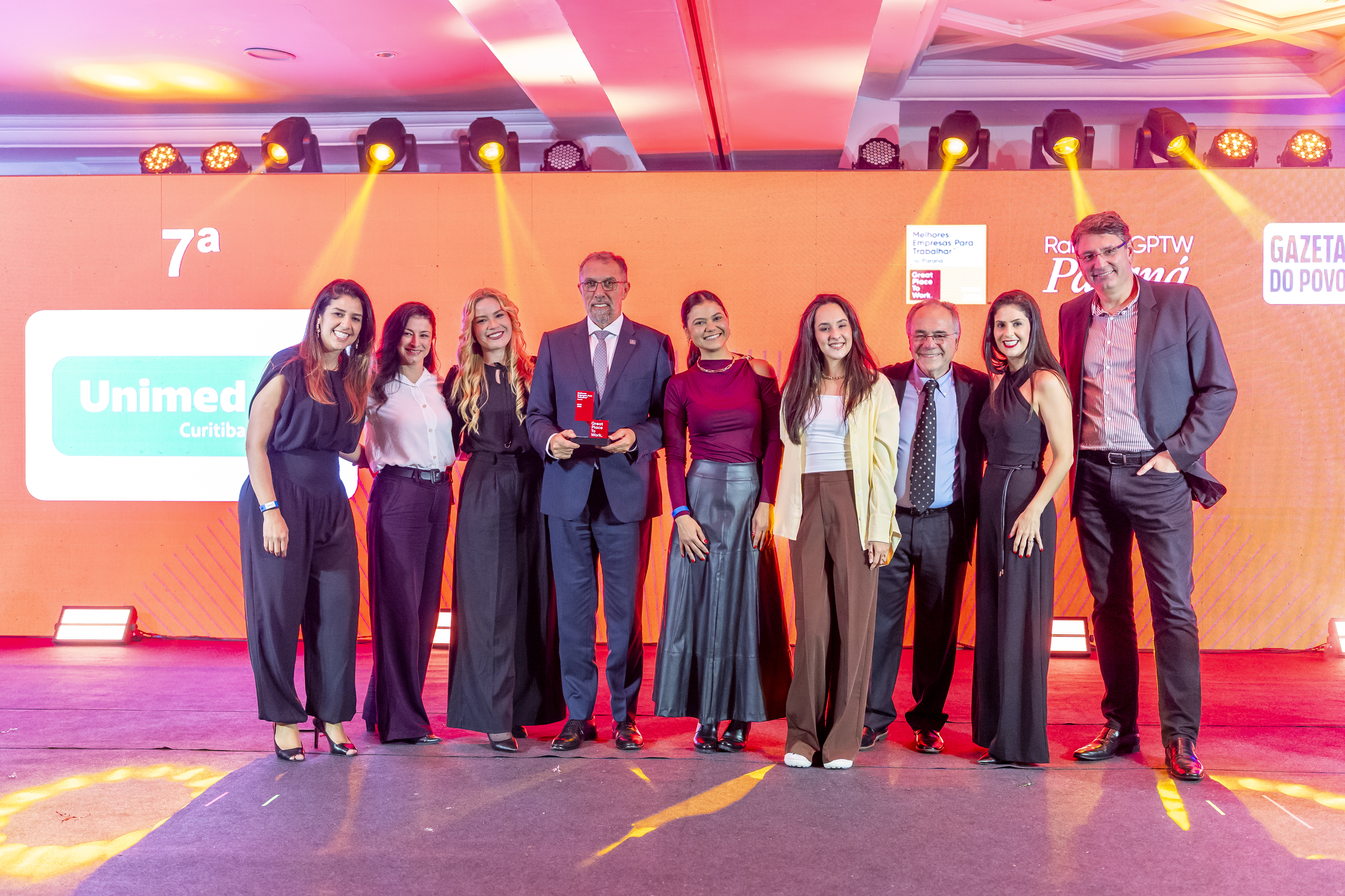 Equipe da Unimed Curitiba no palco para celebrar o reconhecimento no GPTW Paraná 2026, uma conquista que valoriza o trabalho coletivo e o compromisso com as pessoas.