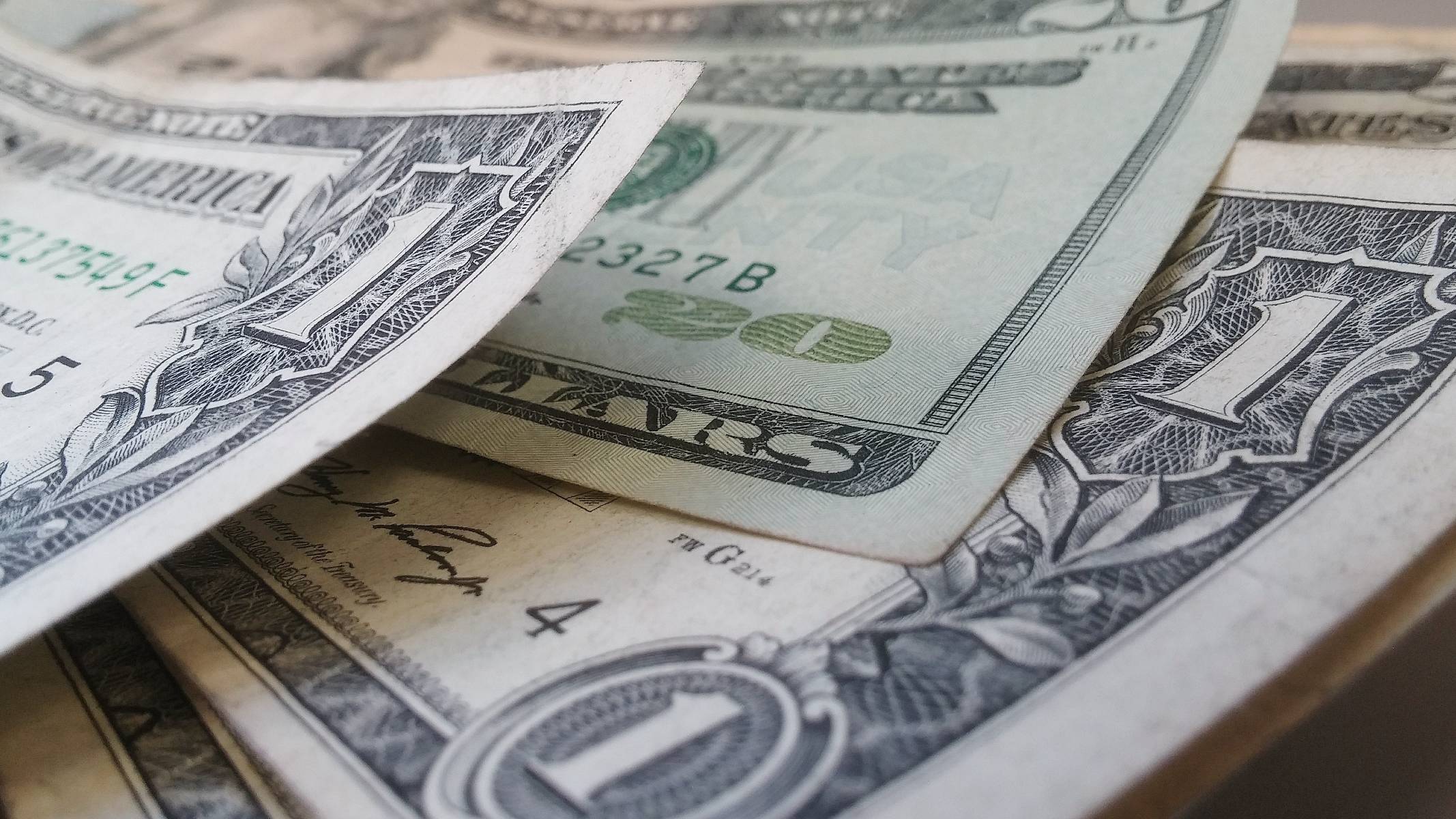 Imagem mostra notas de dólar em um leque.