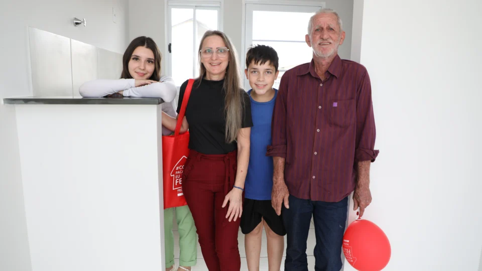Lucia Ferres, de preto, ao lado da família na casa viabilizada em parceria com a cooperativa