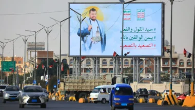 Bandeiras do Iêmen tremulam em um painel digital com o líder houthi Abdul-Malik al-Houthi em uma rua de Sanaa, capital do Iêmen, em meio à escalada de ataques houthis contra a Arábia Saudita