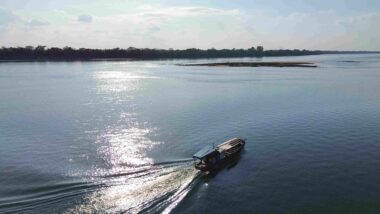 Barco de pescadores artesanais navega em rio, em Imperatriz (MA), no contexto do seguro-defeso