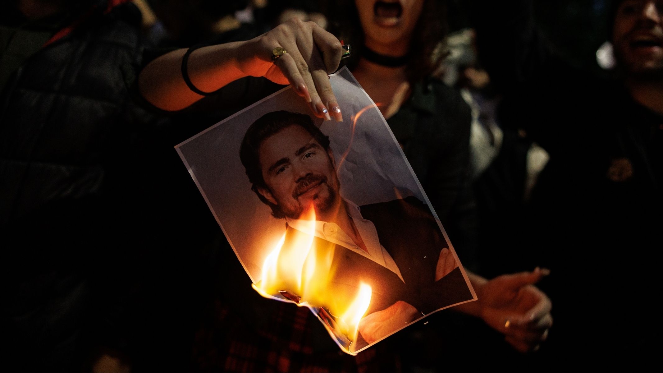 Mulher queima a foto de Daniel Vorcaro em manifestação em janeiro de 2026.