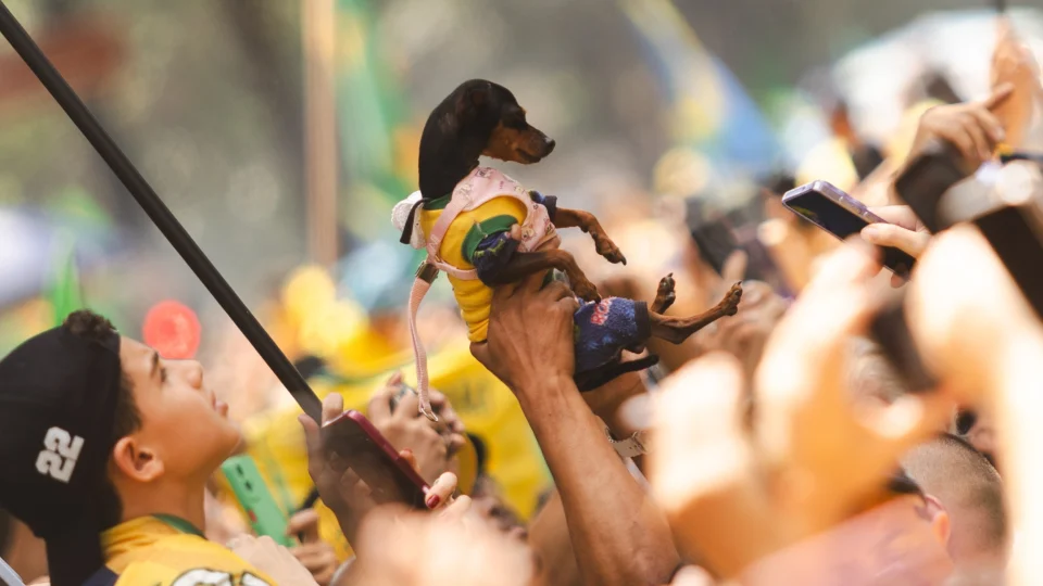 Apoiador segura seu animal de estimação durante o ato.