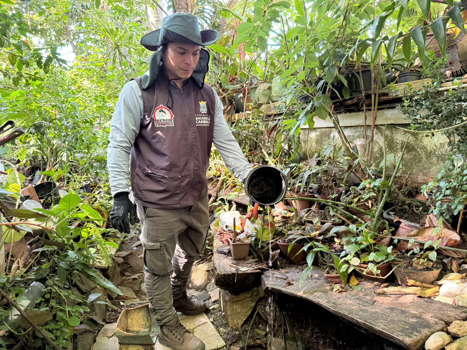 Agente com chapéu, colete da Prefeitura de Balneário Camboriú durante fiscalização da Vigilância Ambiental.